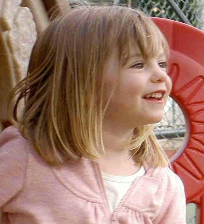 Young girl smiling outdoors, main keyword: Madeleine McCann.