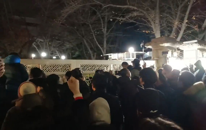 Crowd gathers in South Korea at night after martial law rejection by parliament, highlighting political tension.