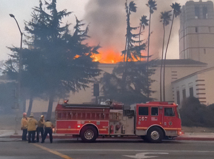Firefighters with truck at building fire.