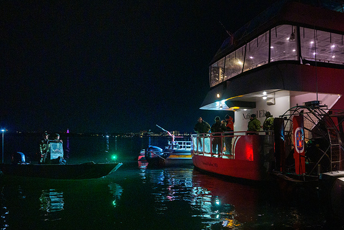 Rescue boats at night after DC plane crash near American Airlines involving passengers.
