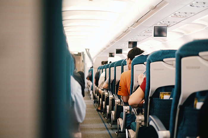 Passengers seated in an airplane cabin, illustrating a flight scenario.