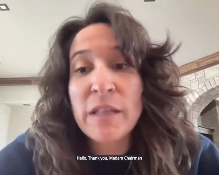Britt Boril in video calls senator "Madam Chairman" in viral act of compliance, wearing casual attire with subtitles visible.