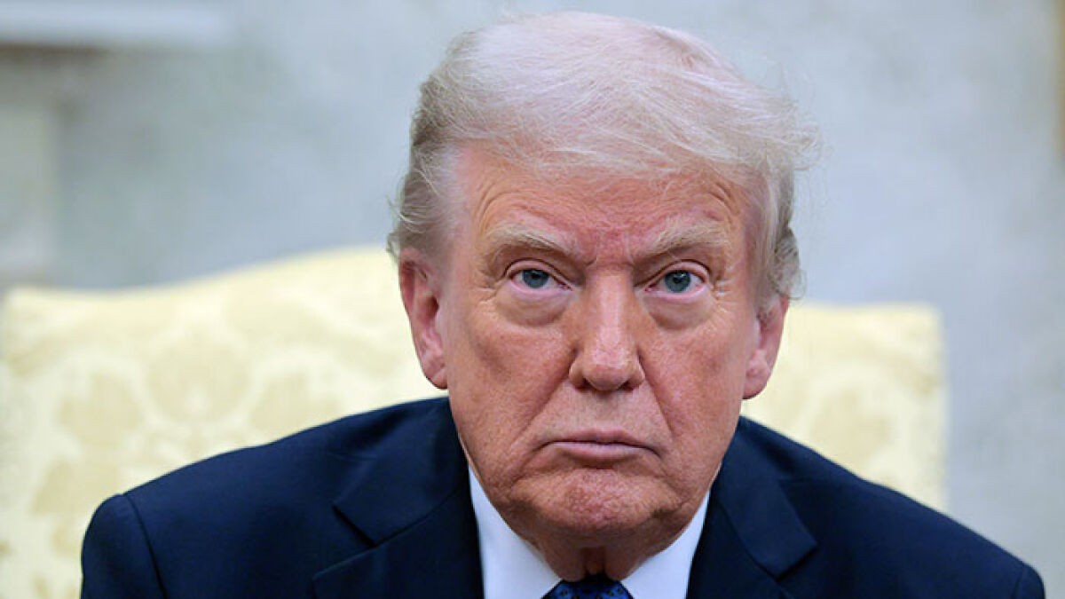 Donald Trump in a serious expression, discussing Columbus Day and the exploreru2019s reputation in a formal setting.