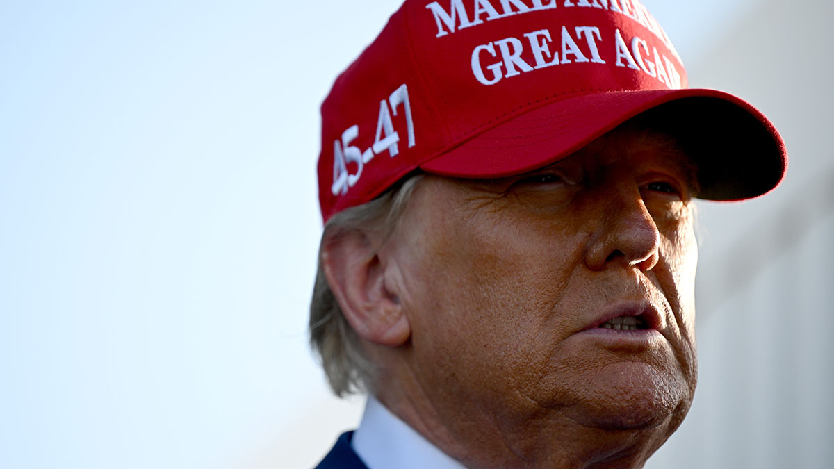 Donald Trump wearing a red Make America Great Again hat during his first 100 days in office discussion.