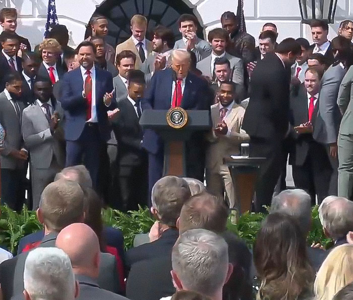 “Keep Them Down”: Trump Pulls Absurd Stunt To Look Taller Than Towering Ohio State Football Team