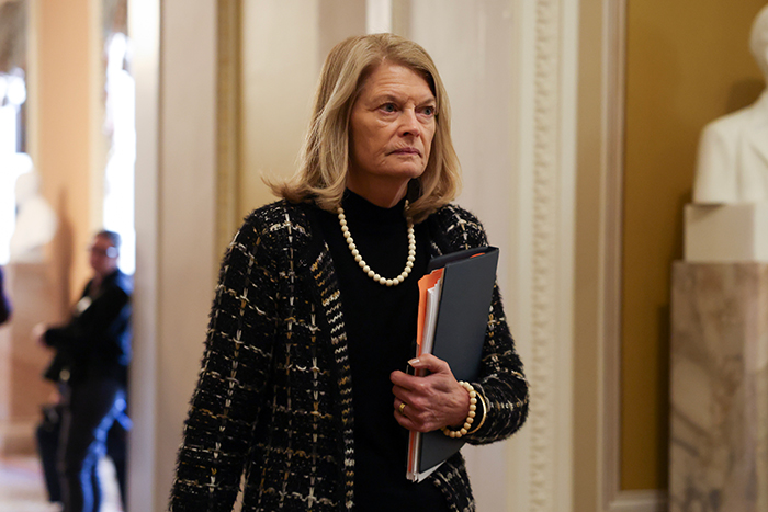 GOP Senator with documents in a hallway, symbolizing political tension and concerns about retaliation.