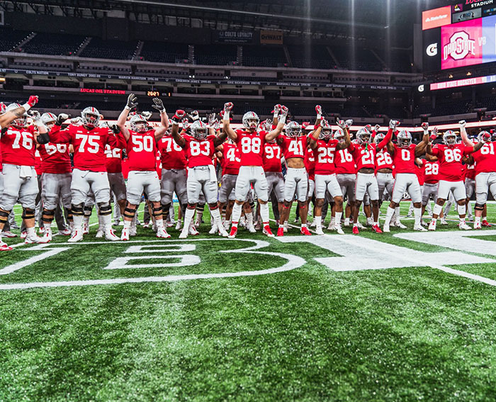 “Keep Them Down”: Trump Pulls Absurd Stunt To Look Taller Than Towering Ohio State Football Team
