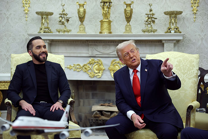 Two men in a formal setting, with one gesturing. El Salvador political context.