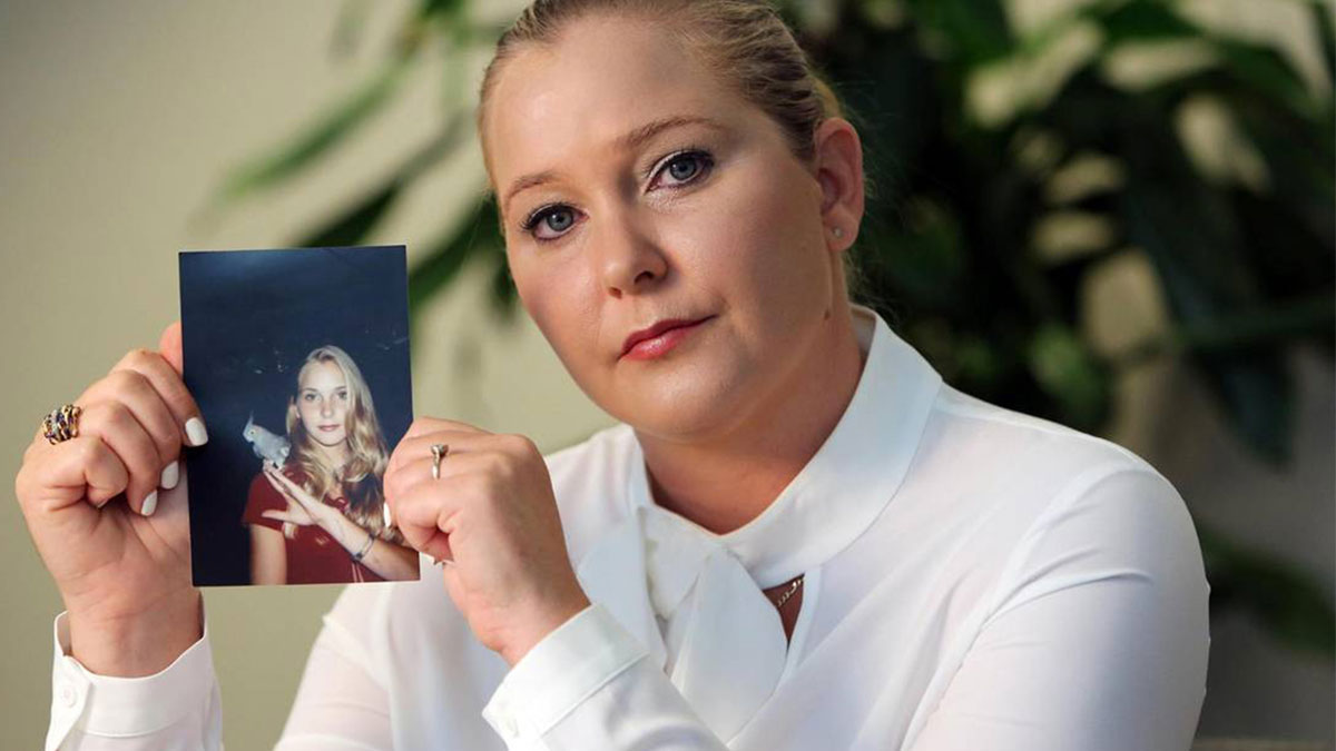Woman in a white blouse holding a photo, expressing concern about Virginia Giuffreu2019s death amid Epstein conspiracy link.