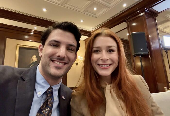 Israeli embassy couple smiling together indoors at a formal event before their upcoming engagement.