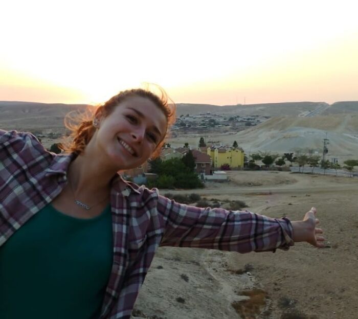 Young woman smiling outdoors with hills and buildings in the background, related to Israeli embassy couple fatally shot news.
