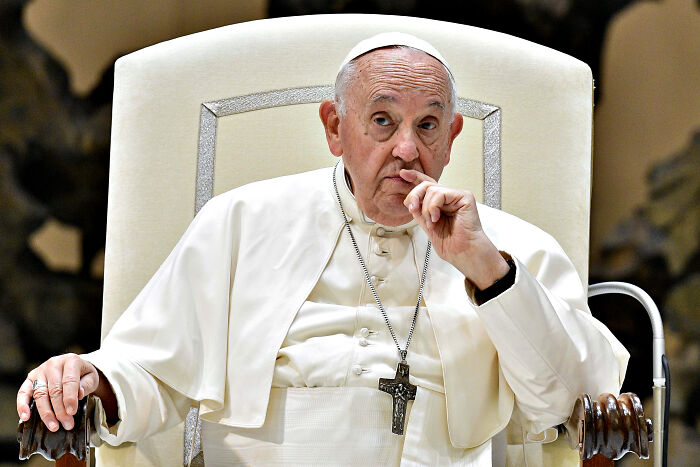Pope Francis seated and thoughtful, representing the popemobile project as a mobile health unit for Gaza children.