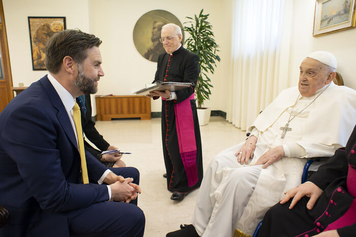 Man in a suit meeting Pope Leo XIV in a formal room, highlighting clues to Pope Leo XIV’s agenda and MAGA controversy.