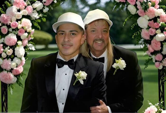 Joe Exotic’s husband and partner wearing tuxedos and hats at an outdoor wedding under floral arch decorations.