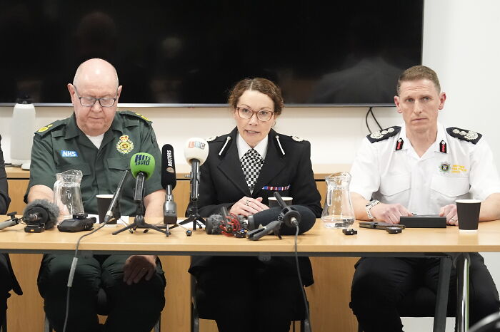 Police officials addressing fans vandalizing suspect’s car before it plows into Liverpool FC parade at a press conference.