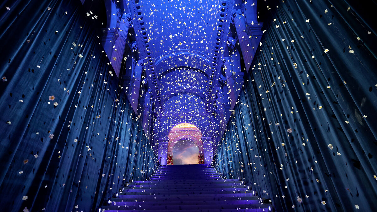 Lavish blue-lit staircase with suspended flowers, representing exclusive Met Gala atmosphere linked to Kamala Harris criticism.