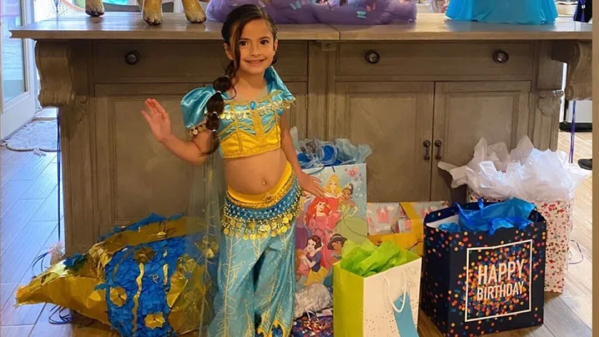 Young girl in a princess costume standing by birthday gifts, related to Louisiana woman killing boyfriendu2019s daughter case.