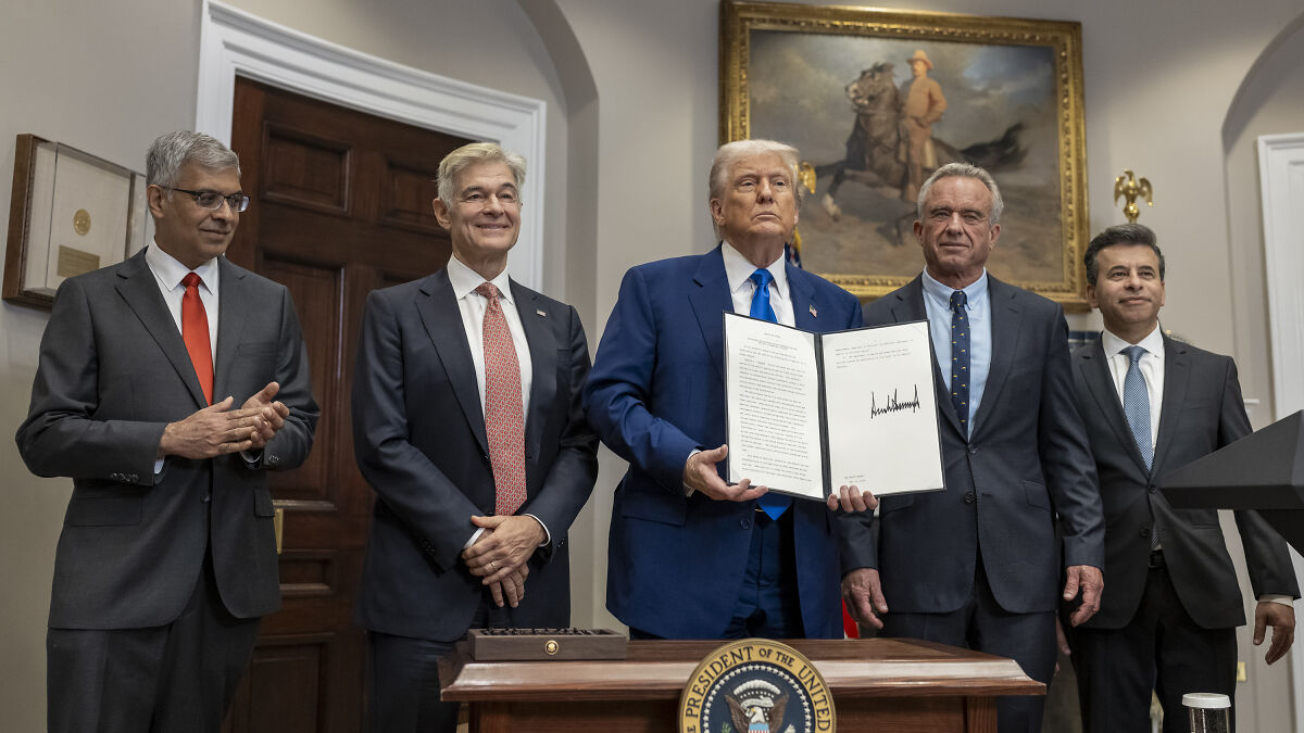 Donald Trump holding signed document with officials, referencing well-known overweight neurotic pal's fat shot abroad.