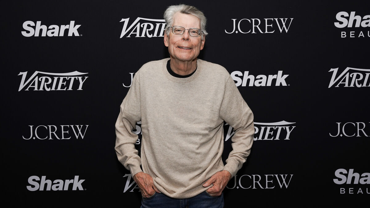 Stephen King at a Variety event, wearing glasses and a beige sweater, responding to racist Trump joke controversy.