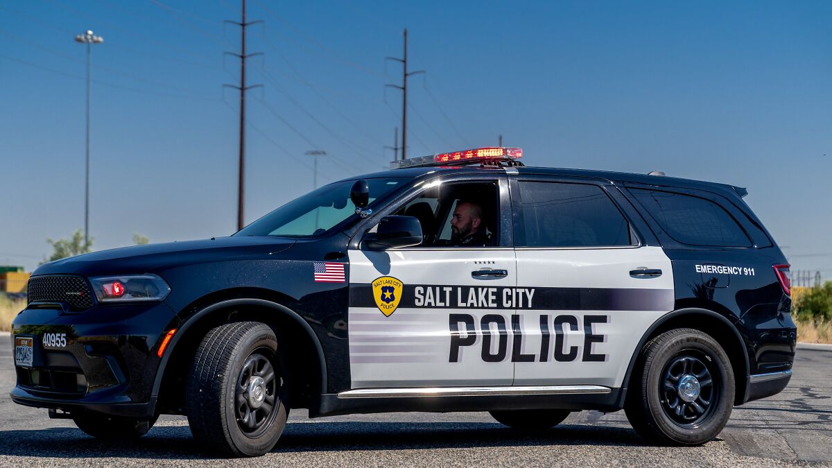 Salt Lake City police SUV with officer inside responding to alleged man holding girlfriend and family hostage.