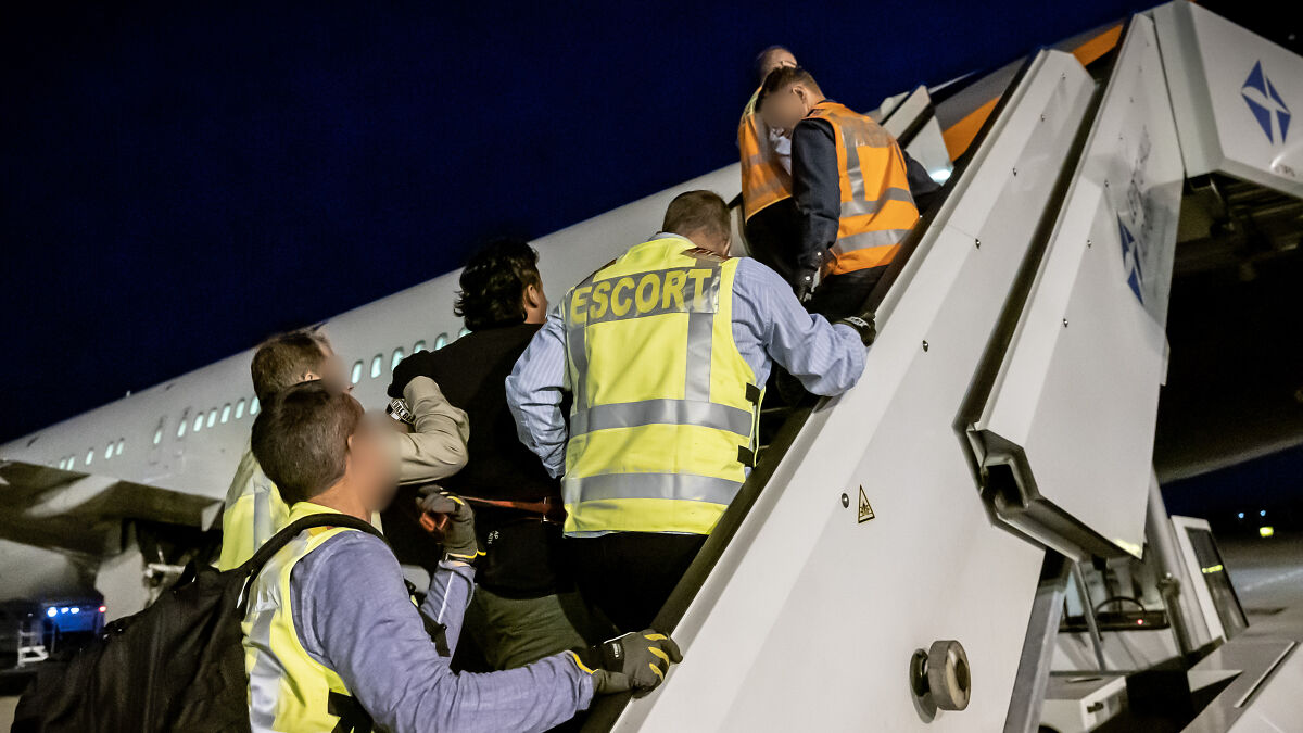 Asian migrants escorted by U.S. officials boarding a plane for deportation to an African country facing civil war risks