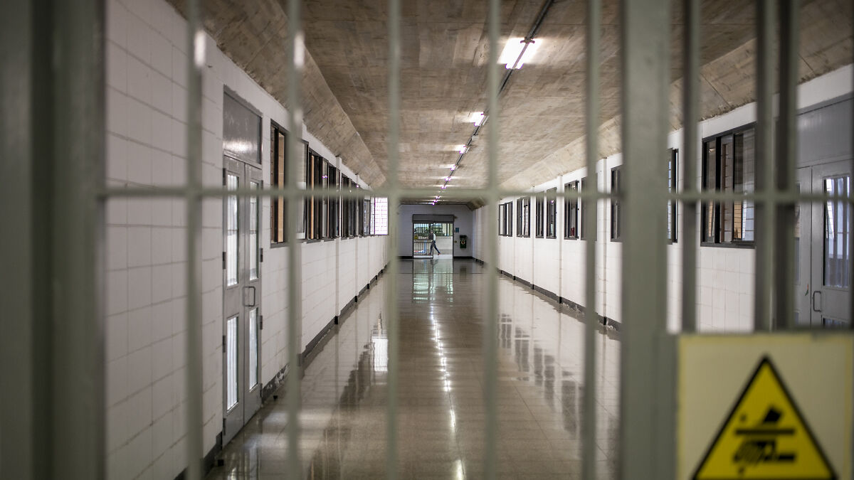 Prison corridor with barred gate in foreground, representing child exploiters and offenders facing harsh crackdown.