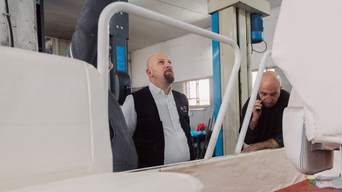 Technicians inspecting the interior of Pope Francis’ Popemobile being converted into a mobile health unit for Gaza children.