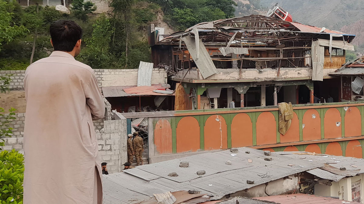 Man in traditional clothing looks at damaged building after India bombs Pakistan raising fears of war between nuclear-armed rivals