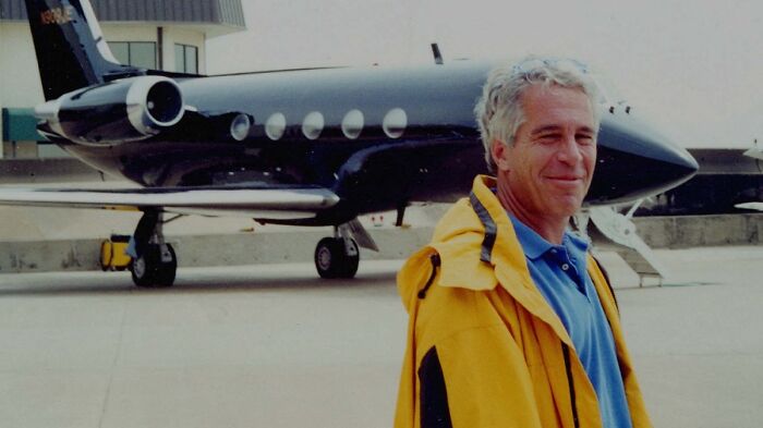 Man in yellow jacket standing near private jet, related to audio resurfaces and Lolita Express keywords.