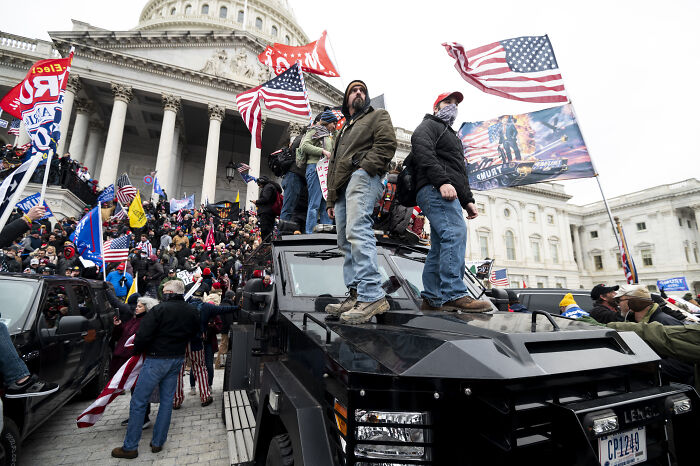 Supporters waving American flags during a Jan 6 riot at the Capitol highlighting MAGA Granny pardon rejection claims
