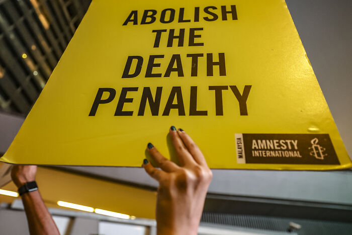Protesters holding a yellow sign calling to abolish the death penalty amid Japan‘s execution of Twitter Killer case.