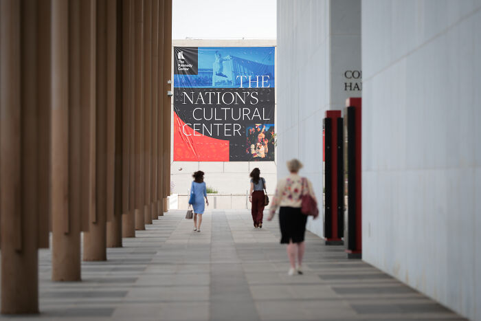 People walking toward a building with a banner reading Nation’s Cultural Center on Donald and Melania Trump Les Misérables event