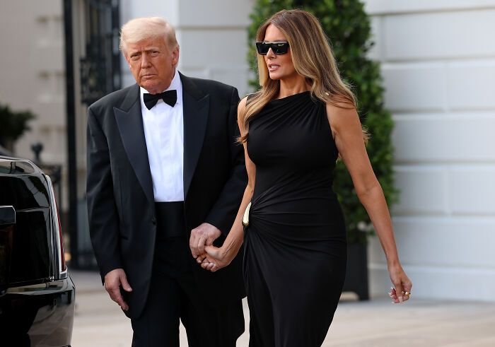 Donald and Melania Trump arriving holding hands, dressed elegantly at Les Misérables opening night event.