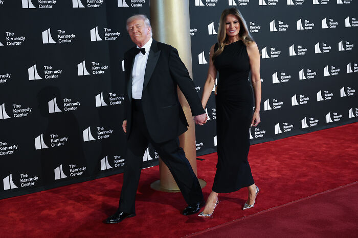 Donald and Melania Trump walking the red carpet at Les Misérables opening night with mixed audience boos and cheers.