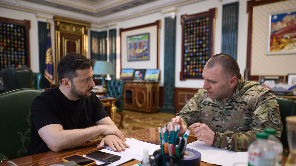 Two men discussing at a table with documents in an ornate room, highlighting concerns of Putin striking NATO forces.