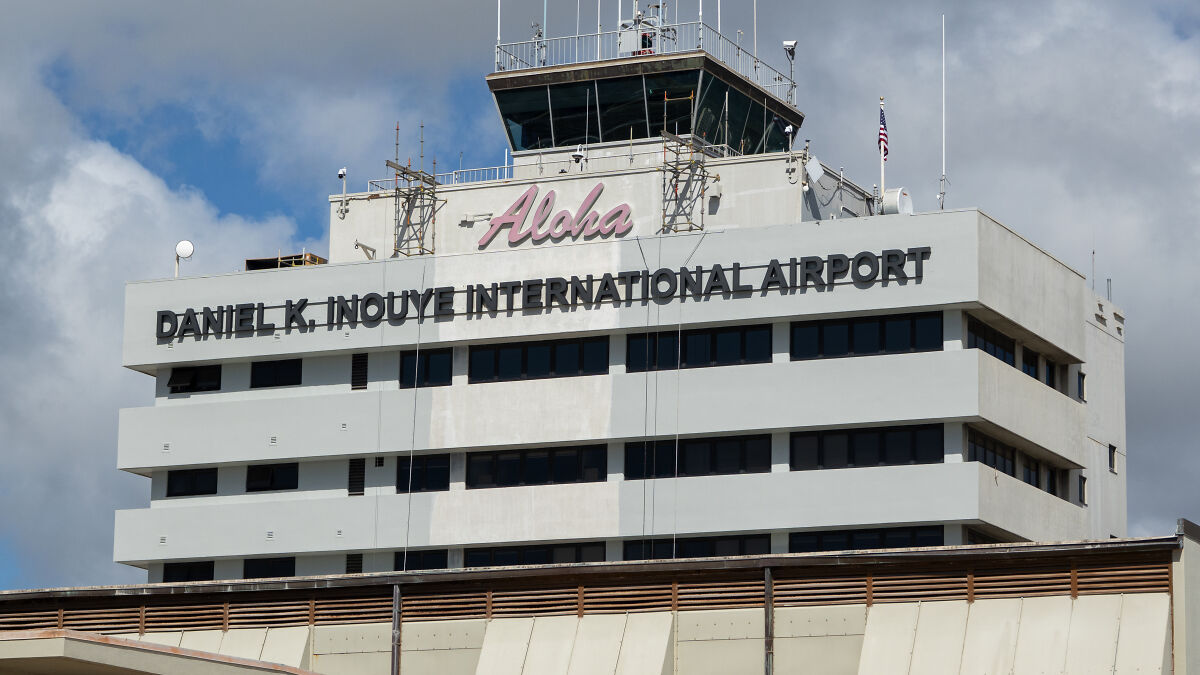 Daniel K Inouye International Airport control tower under partly cloudy sky, representing DHS and agent response at airport.