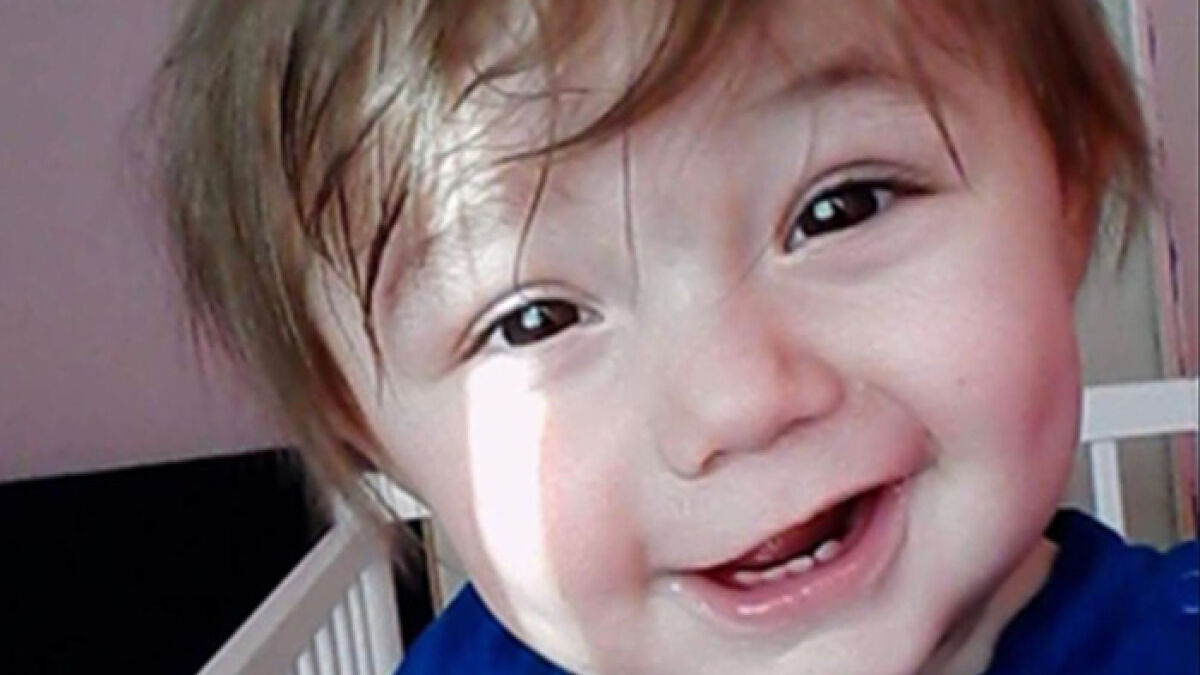 Toddler smiling in a close-up photo, highlighting the case of ongoing abuse and painful thinness from grandparents.