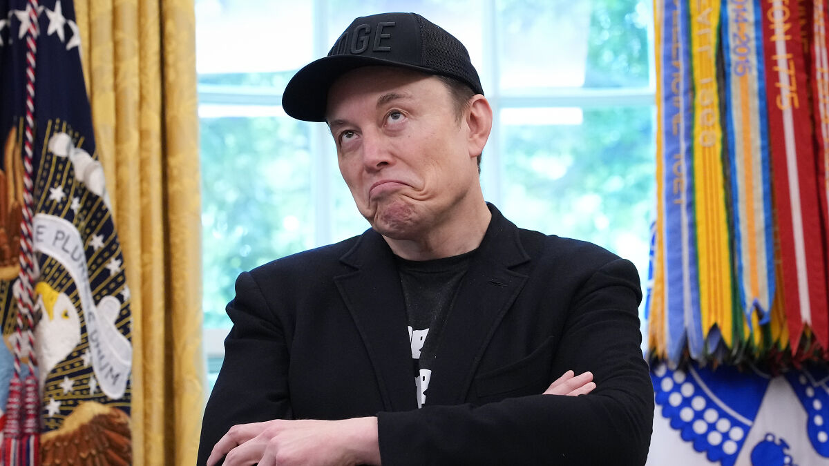 Elon Musk wearing black cap and jacket inside a government office, symbolizing Russia offers political asylum.