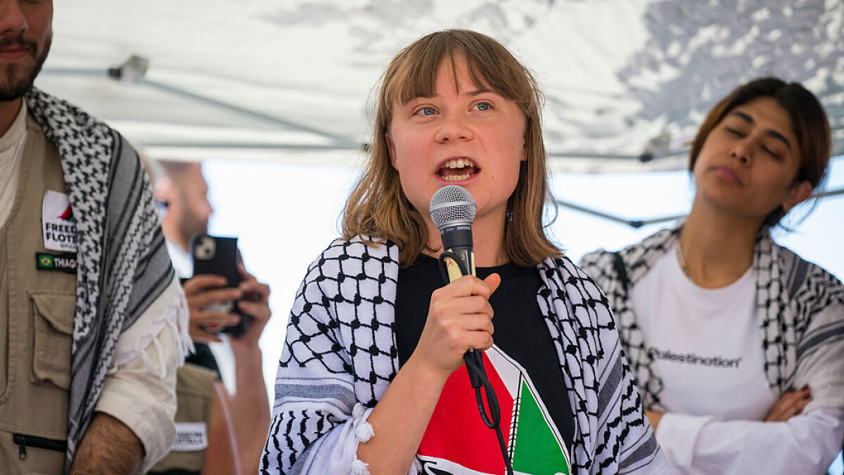 Greta Thunberg speaking into a microphone aboard an aid ship amid claims of Israeli officials mistreatment by French medic.