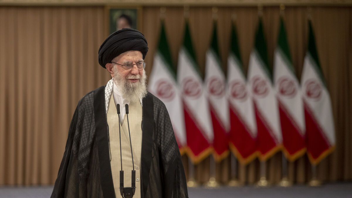 Iranu2019s Supreme Leader speaking at a podium with Iranian flags in the background during a public warning to the U.S.
