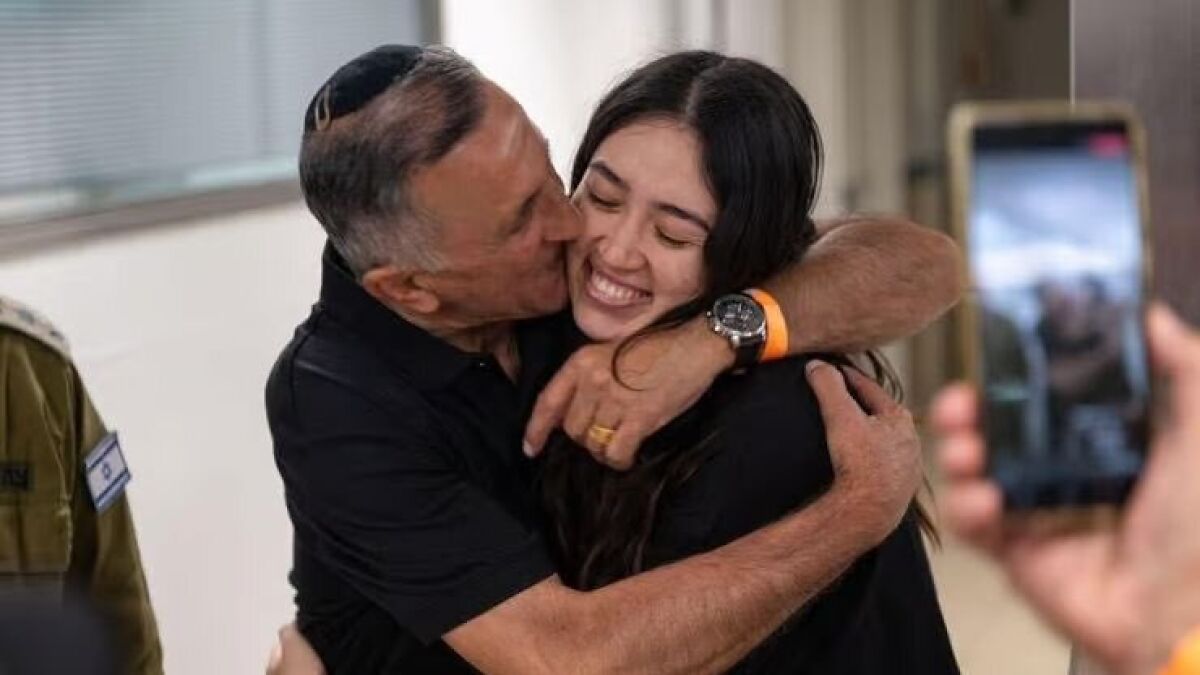 Man hugging young woman, celebrating October 7 hostage resettlement amid tensions with terror sympathizers.