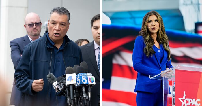 Man speaking forcefully at press conference with multiple microphones, woman in blue suit at podium behind American flag backdrop