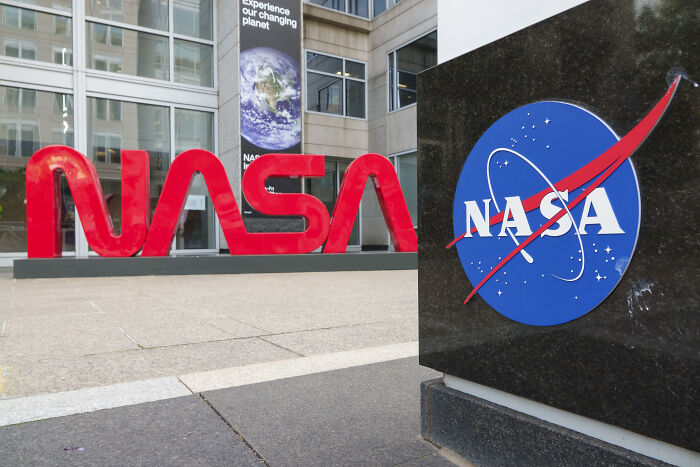 NASA logo on a building exterior with large red NASA letters in the background representing Trump’s new NASA boss news.
