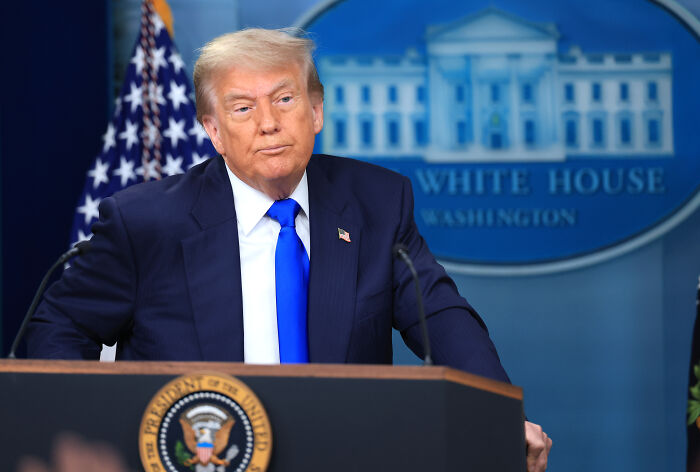 Donald Trump speaking at a White House podium, discussing Musk, DOGE, and billionaire feud topics.