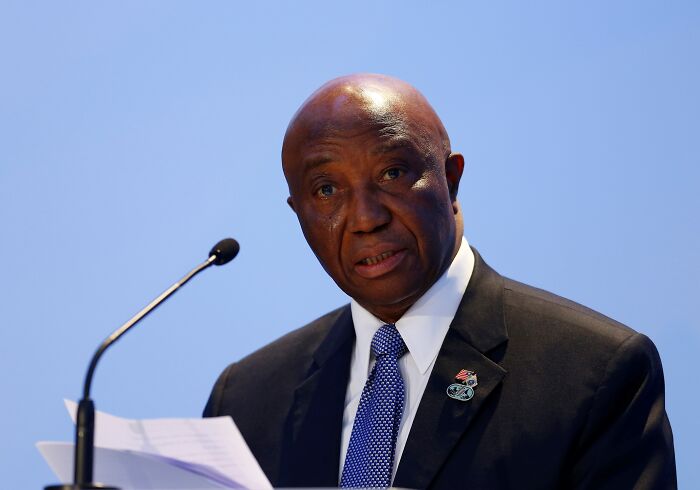 Liberian president speaking at a podium, dressed in suit and tie, amid Trump’s comment backlash on English skills across Africa.