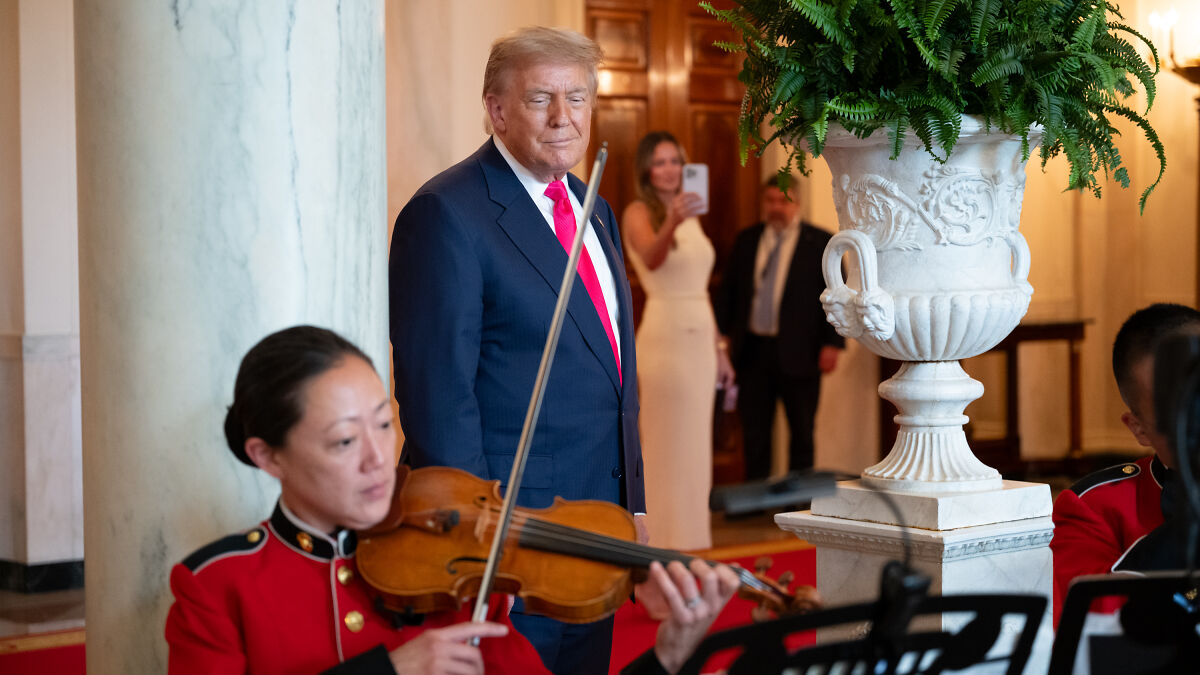 Donald Trump listening to violin music during a formal event, highlighting emotional moments and neocon war hawk influence.