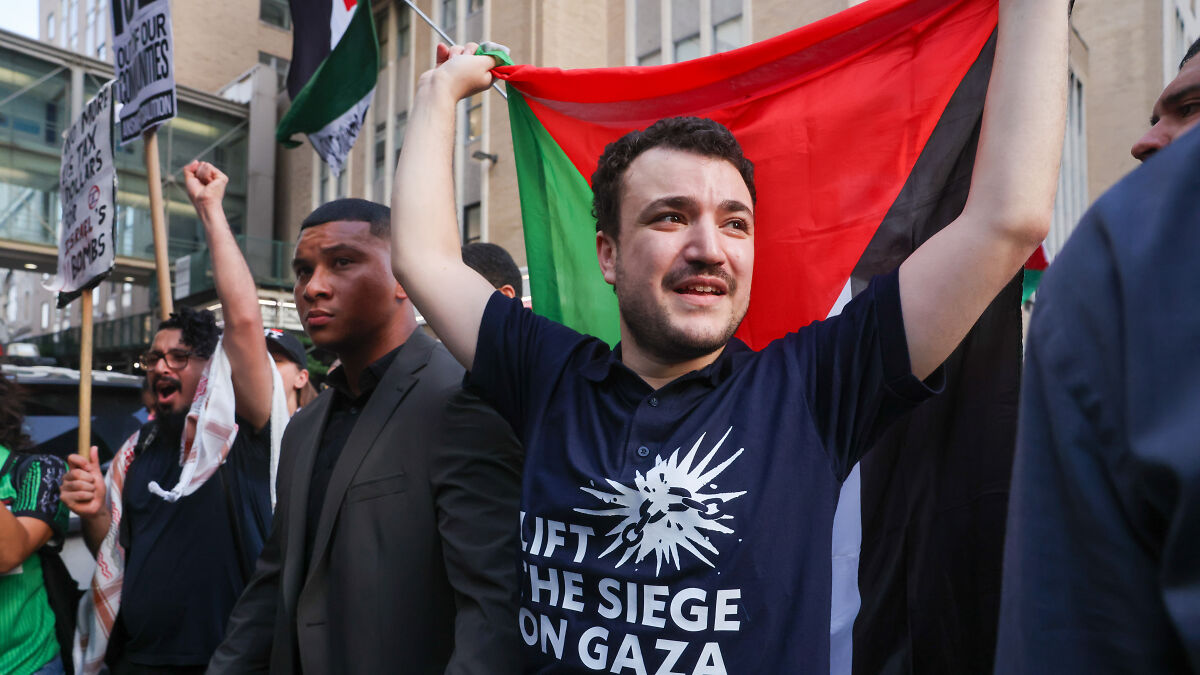 Activist Mahmoud Khalil holds a flag and leads a protest demanding accountability after ICE detention.